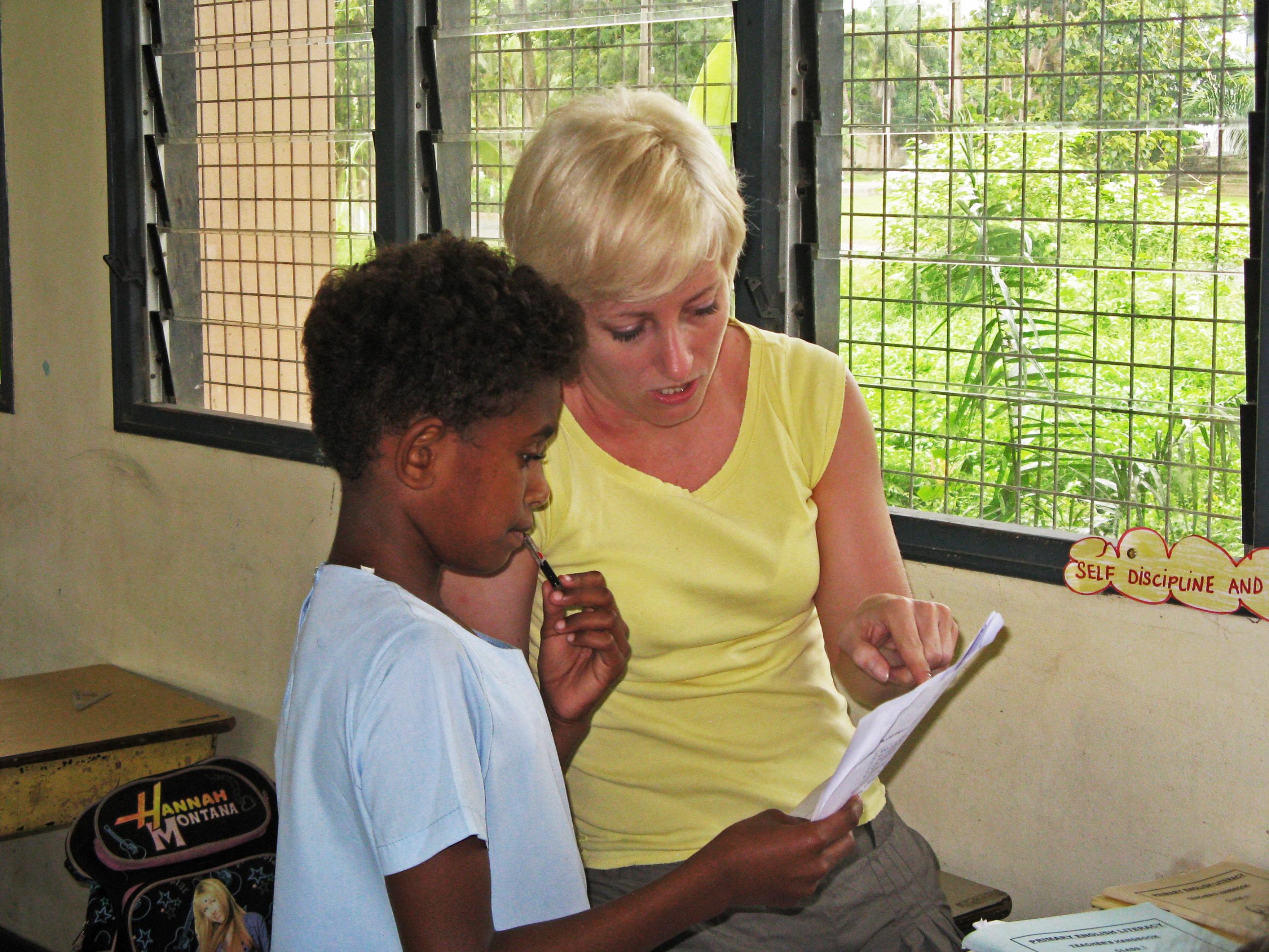 A Projects Abroad volunteer teaching English in Fiji helps her student with a grammar exercise A volunteer gains teaching work experience in Fiji while helping a young boy with his schoolwork